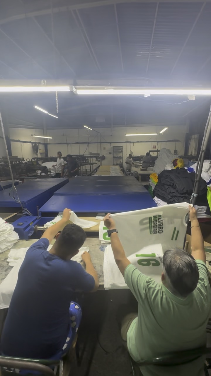 Equipo revisando playeras impresas de campaña al final de la línea