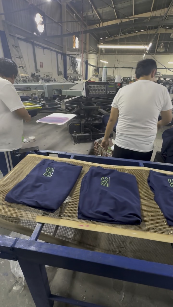 Playeras impresas y dobladas al final de la línea de producción